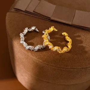 Gros plan de bagues torsadées avec pierres de zircon en finitions argent et or.