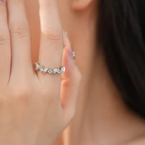 Gros plan d'une bague élégante en argent torsadée sertie de zircons brillants.