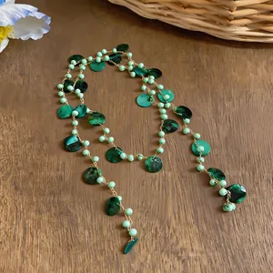 Vista dettagliata della collana di perline di conchiglia verde bohémien su un tavolo