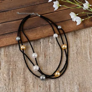 Double-strand black beaded necklace with mixed color pearls on rustic wooden background