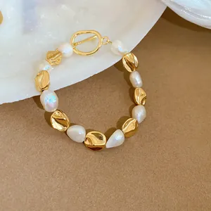 Close-up detail of a French style freshwater pearl bracelet featuring a gold OT buckle