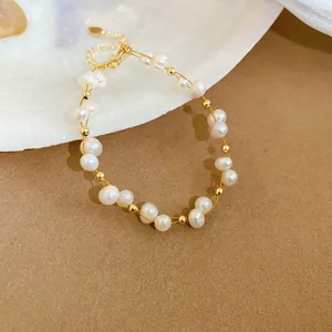 Close-up detail of a handmade freshwater pearl bracelet with elegant gold spacer beads