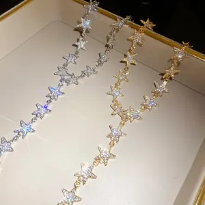 Gros plan de colliers d'étoiles sertis de strass or et argent dans un plateau à bijoux
