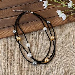 Detail of a multi-layer black beaded necklace with large pearls on a rustic background.