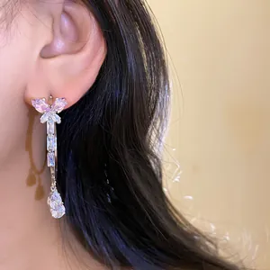 Close-up shot of elegant butterfly zircon hoop earrings with a teardrop dangle on an ear