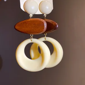 Detail shot of vintage resin and wood drop earrings with a retro bohemian aesthetic.