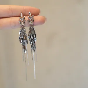 Detailed view of silver wheat ear tassel earrings with white zircon accents