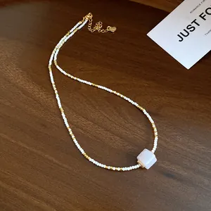 Detailaufnahme einer handgefertigten Perlenkette mit einem zartrosa Steinanhänger