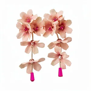 Élégantes boucles d'oreilles à fleurs en tissu rose avec pompons, perles et cristaux.