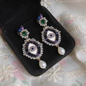 Ornate gothic Evil Eye drop earrings featuring colorful rhinestones and elegant white pearls