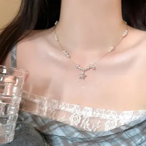 Gros plan d'un collier de perles élégant avec des pendentifs étoiles scintillants.