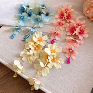 Vue détaillée de boucles d'oreilles à pampilles en fleurs de tissu bleu, rose et crème