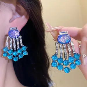 Close-up of vintage oval resin tassel earrings with blue shimmering beads