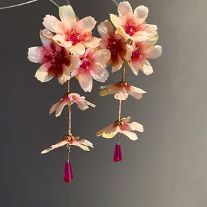 Vue détaillée des boucles d'oreilles pendantes en fleur de tissu style vacances roses