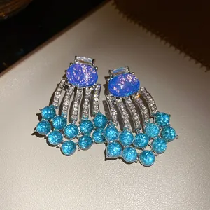 Close-up of vintage luxury blue resin earrings with rhinestone tassels and bead fringe