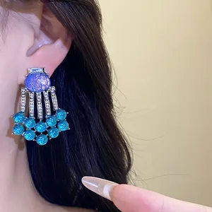Detailed close-up of vintage resin tassel earrings featuring blue beads and sparkling crystals
