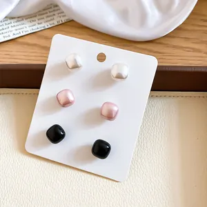 Set of French vintage square pearl stud earrings in white, pink, and black colors.