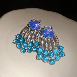 Close-up of vintage oval resin rhinestone tassel earrings with star blue finish