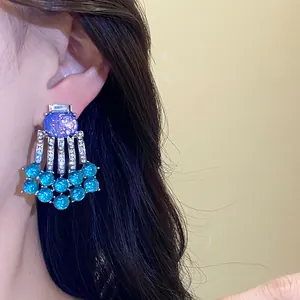 Close-up detail of luxurious vintage-style resin and rhinestone tassel earrings worn on ear