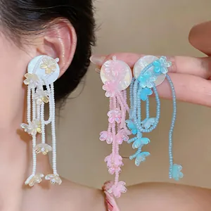 Detail view of dopamine colorful flower tassel beaded earrings in pink, blue, and white colors