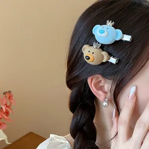 Close-up showing the soft flocked texture of cute bear hair clips with crown accents