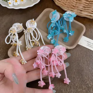 Detailed view of colorful beaded flower tassel earrings in pink blue and white