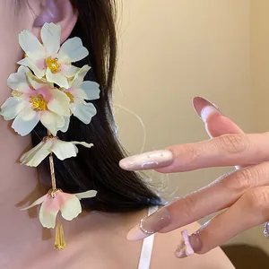 Vue détaillée des boucles d'oreilles à fleurs en tissu avec pétales pastel