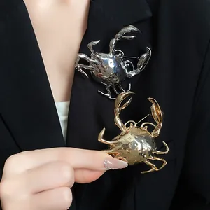 Detailed view of creative 3D metallic crab brooches in gold and silver on a black blazer.