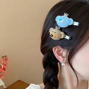 Close-up of cute flocked bear hair clips with crowns worn in a dark braided hairstyle