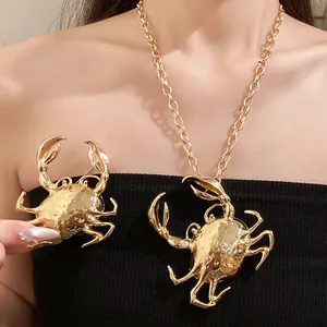 Close-up of exaggerated gold metallic crab pendant necklace and matching brooch accessory