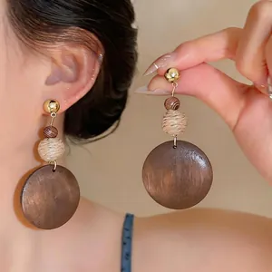Vintage ethnic style wooden drop earrings with round pendant and woven ball detail