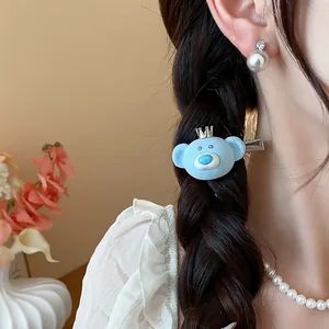 Close-up detail shot of cute blue flocked bear hair clip on braided hair with pearls