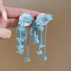 Detailed view of light blue floral tassel beaded earrings with pearlescent studs