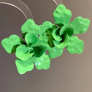Primer plano de pendientes de pétalos de flores verdes con acabado de esmalte brillante