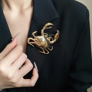 Exquisite close-up of a large gold metallic crab brooch styled on a black blazer lapel