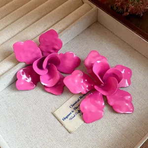 Primer plano de pendientes de flores de esmalte rosa brillante en un joyero de lujo