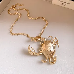 Detailed view of a chunky gold chain necklace featuring a textured 3D crab pendant.