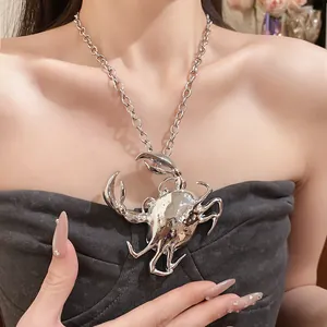 Detailed close-up of a silver 3D crab pendant necklace worn by a model