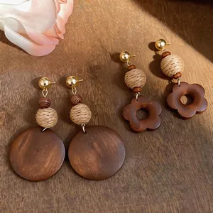 Detailed view of vintage wooden drop earrings with woven beads and geometric pendants