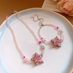 Détail de l'ensemble collier et bracelet en perles roses avec étoiles en strass étincelantes