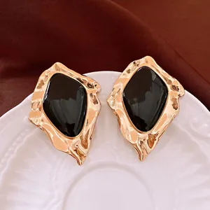Orecchini a perno geometrici vintage con centro in smalto nero e finitura in oro martellato