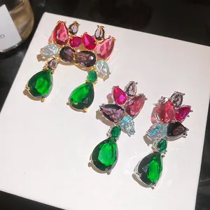 Detail of luxury teardrop earrings with vibrant multi-color zircons on white display