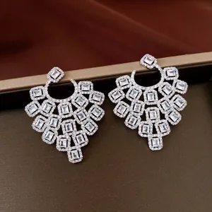 Dettaglio di orecchini geometrici in argento con brillanti zirconi rettangolari