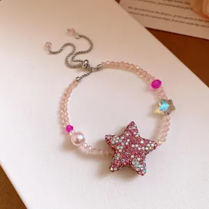 Vue détaillée du charme d'étoile en zircon rose et des perles sur bracelet