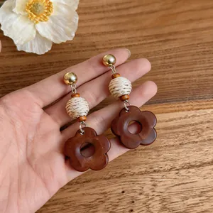 Detailed view of vintage ethnic wooden flower drop earrings with woven raffia beads
