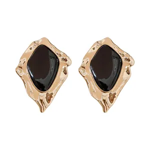 Orecchini geometrici vintage con smalto nero e finitura dorata martellata