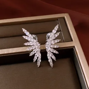 Detailed macro view of crystal-encrusted wing-shaped ear clips for non-pierced ears.