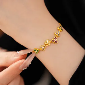 Close-up of a gold floral bracelet featuring colorful zircon charms on a model's wrist