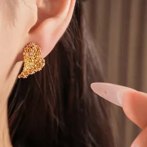 Élégantes boucles d'oreilles cœur en or 18K avec zircons portées par un mannequin