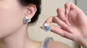 Detaillierte Ansicht von bunten Perlen-Blumen-Ohrsteckern, getragen von einem Model
